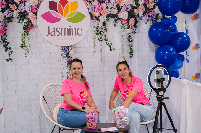 Dos emprendedoras sentadas y sonrientes en la Feria Estilo Mam